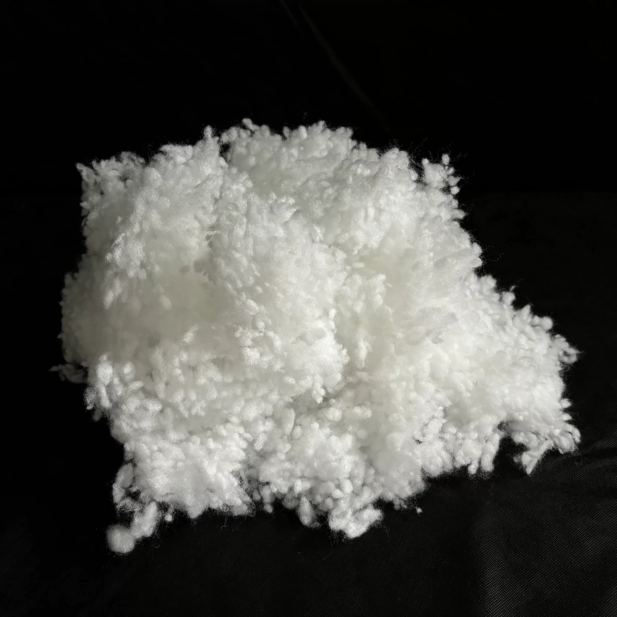 Detail dutého vlákna na černém pozadí – kvalitní výplňový materiál s jemnou strukturou.